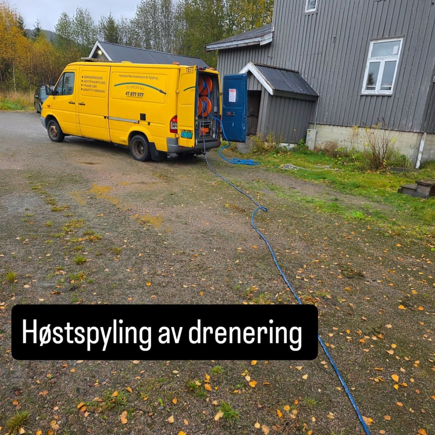 Spylebilen står inntil en bygning under høstspyling av drenering